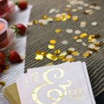 Close-up of 'Mr & Mrs' napkins with golden confetti on a table setting, perfect for weddings.